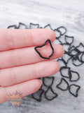 Black cat 3D printed stitch markers held between fingers with more clips in the background.