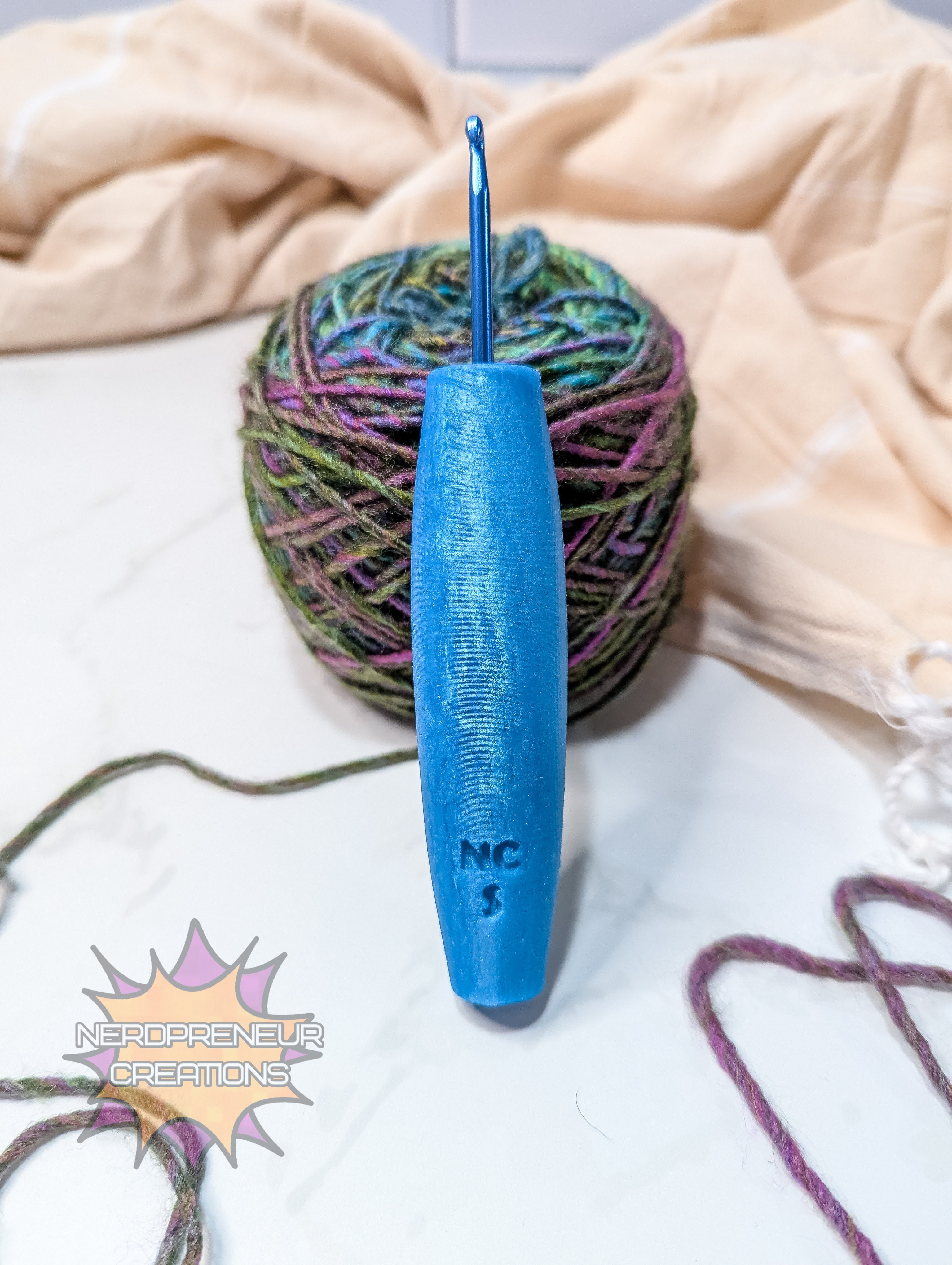 Blue crochet hook with a ball of yarn on a light background
