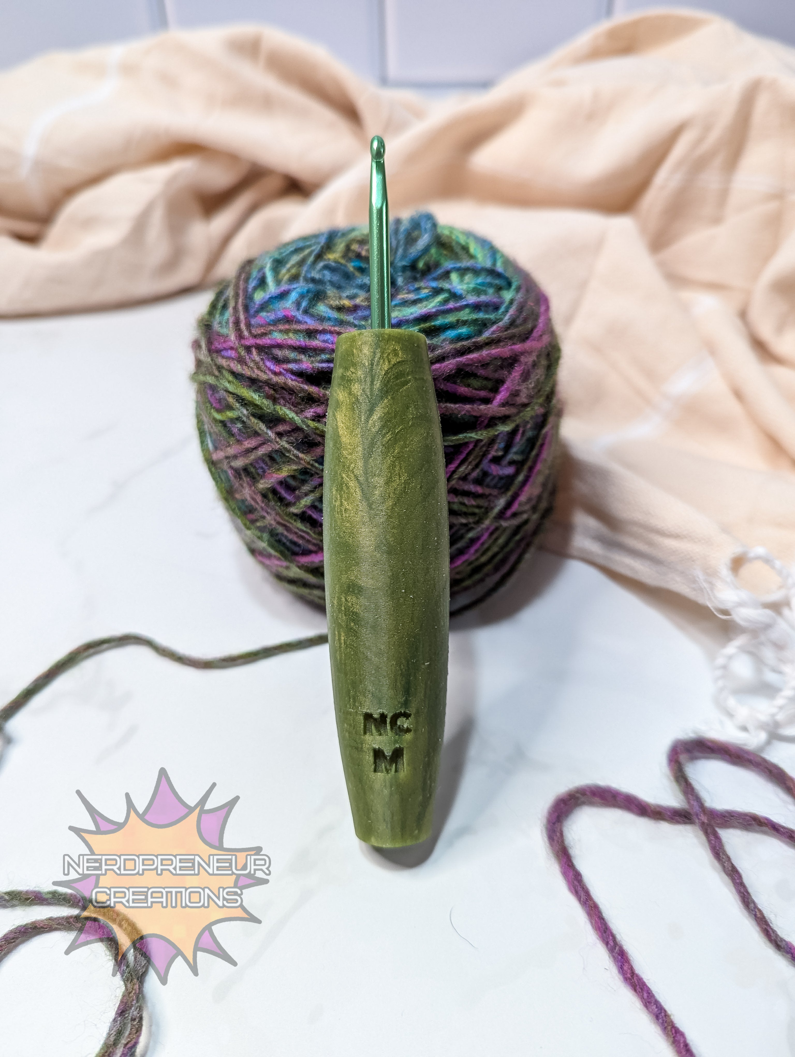 Green silicone crochet hook with yarn and colorful yarn ball on a light background