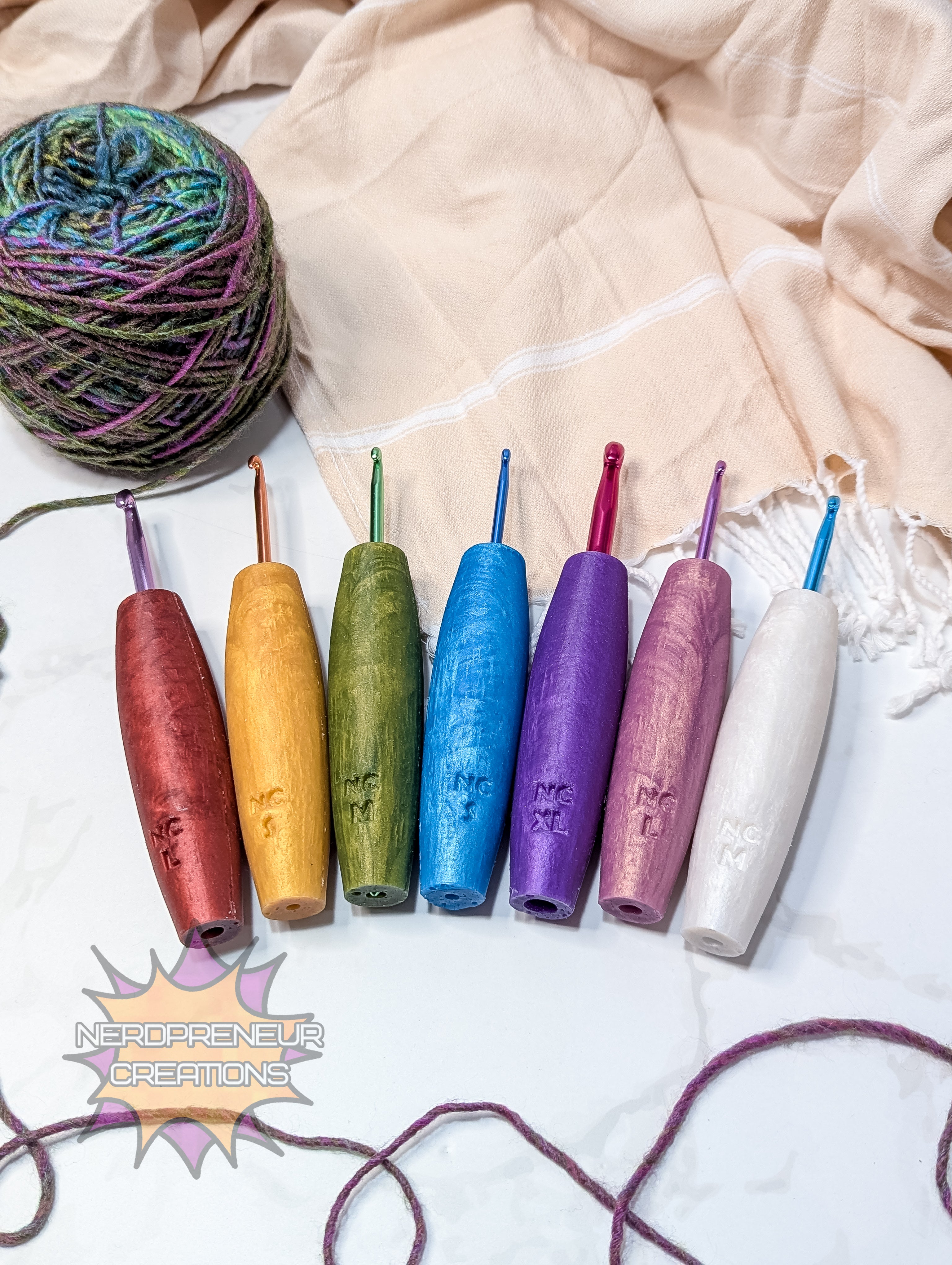 Set of colorful silicone crochet hooks on a textured fabric background with a ball of yarn.