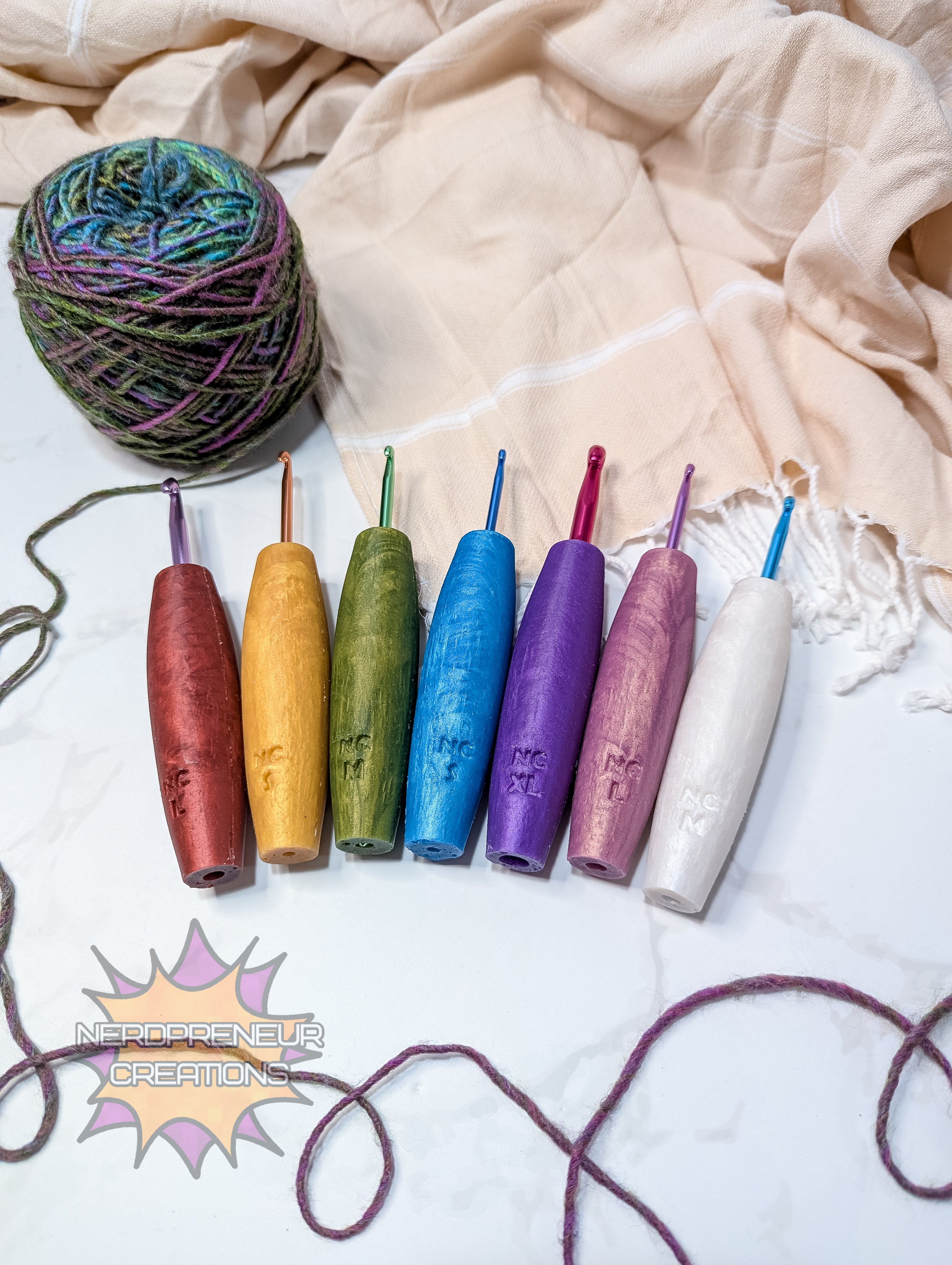 Set of colorful silicone crochet grips with a ball of yarn on a textured fabric background