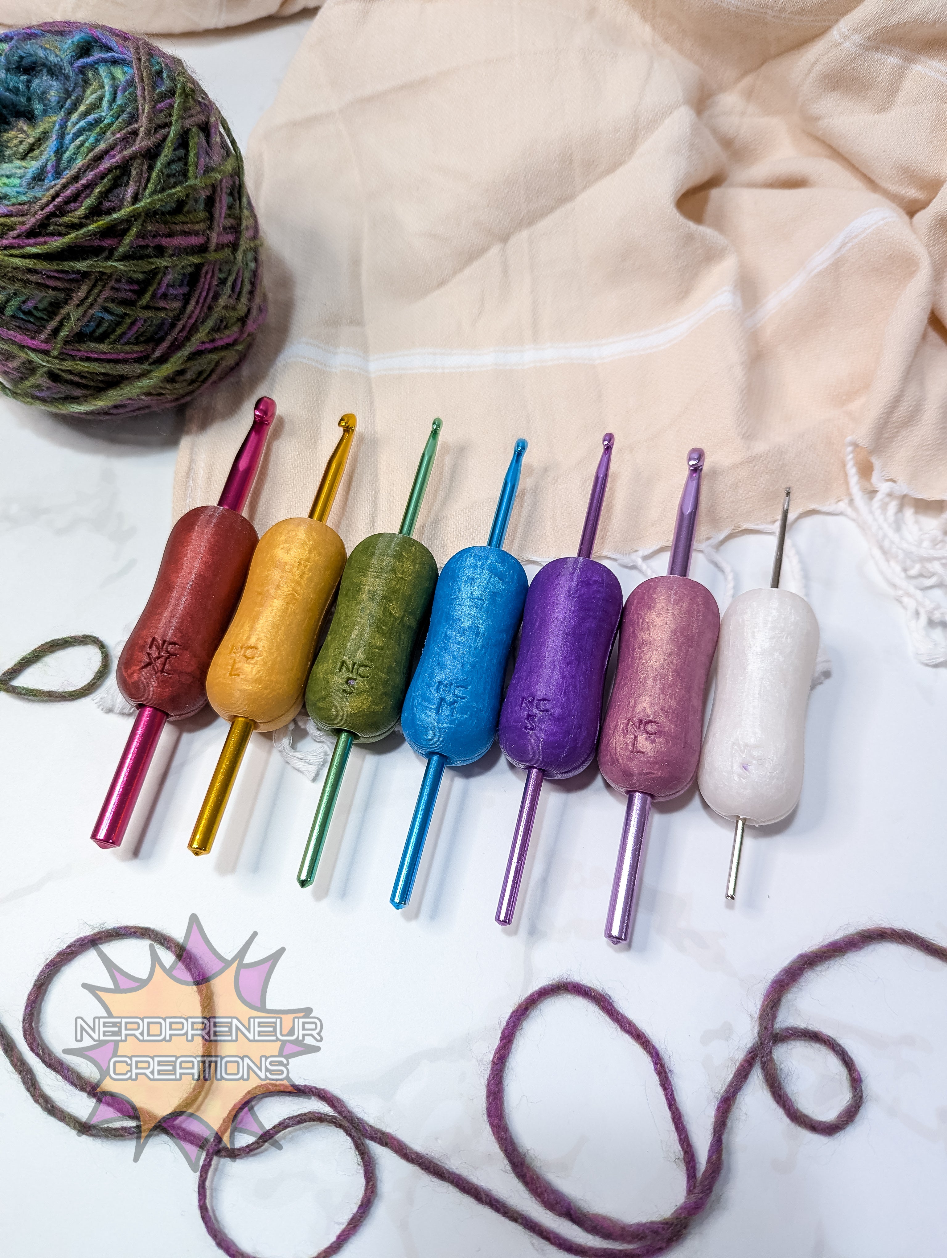 Set of colorful silicone crochet grip on a textured fabric background with yarn.