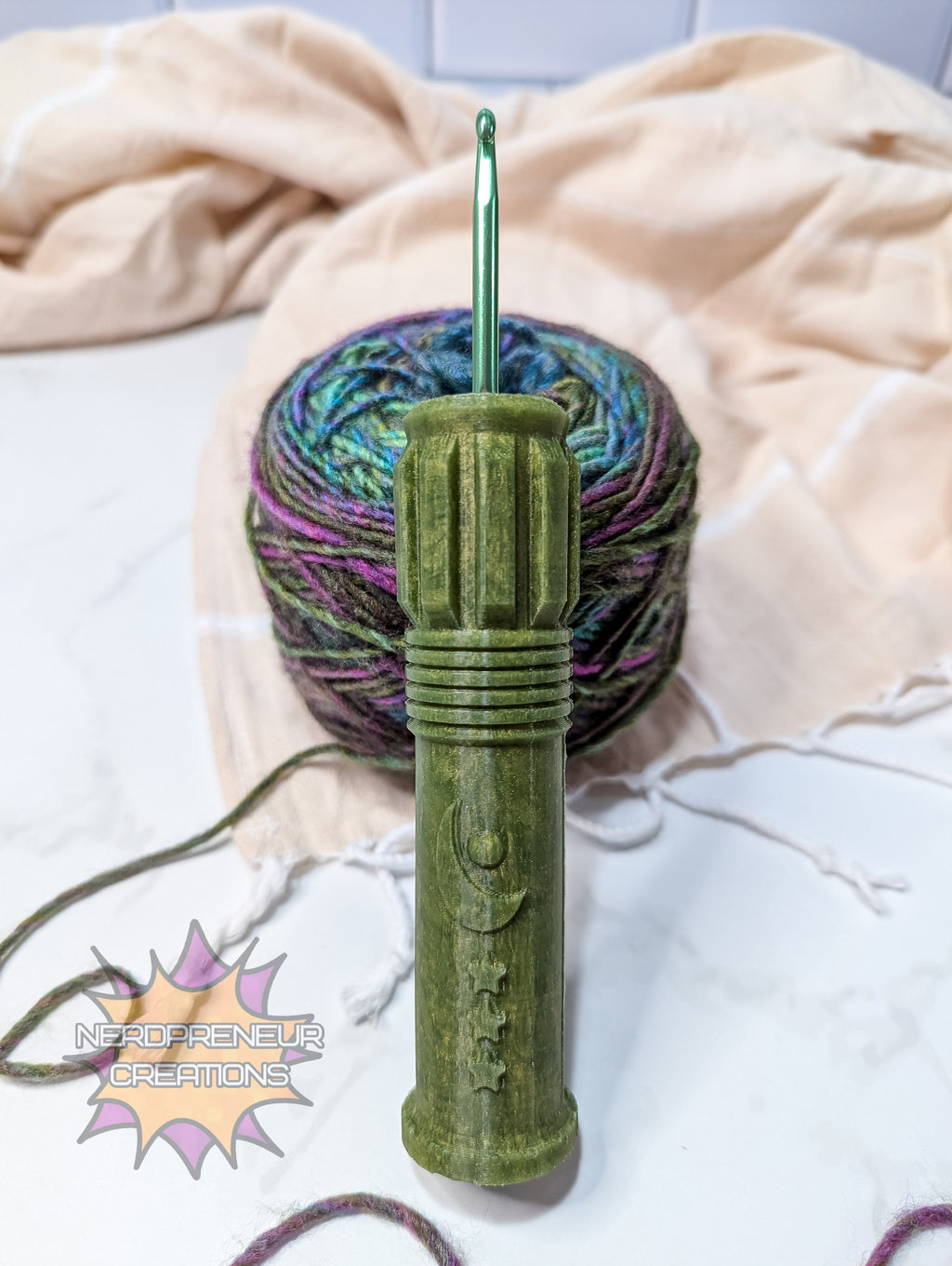 Green silicone crochet grip with a ball of multicolored yarn on a light background