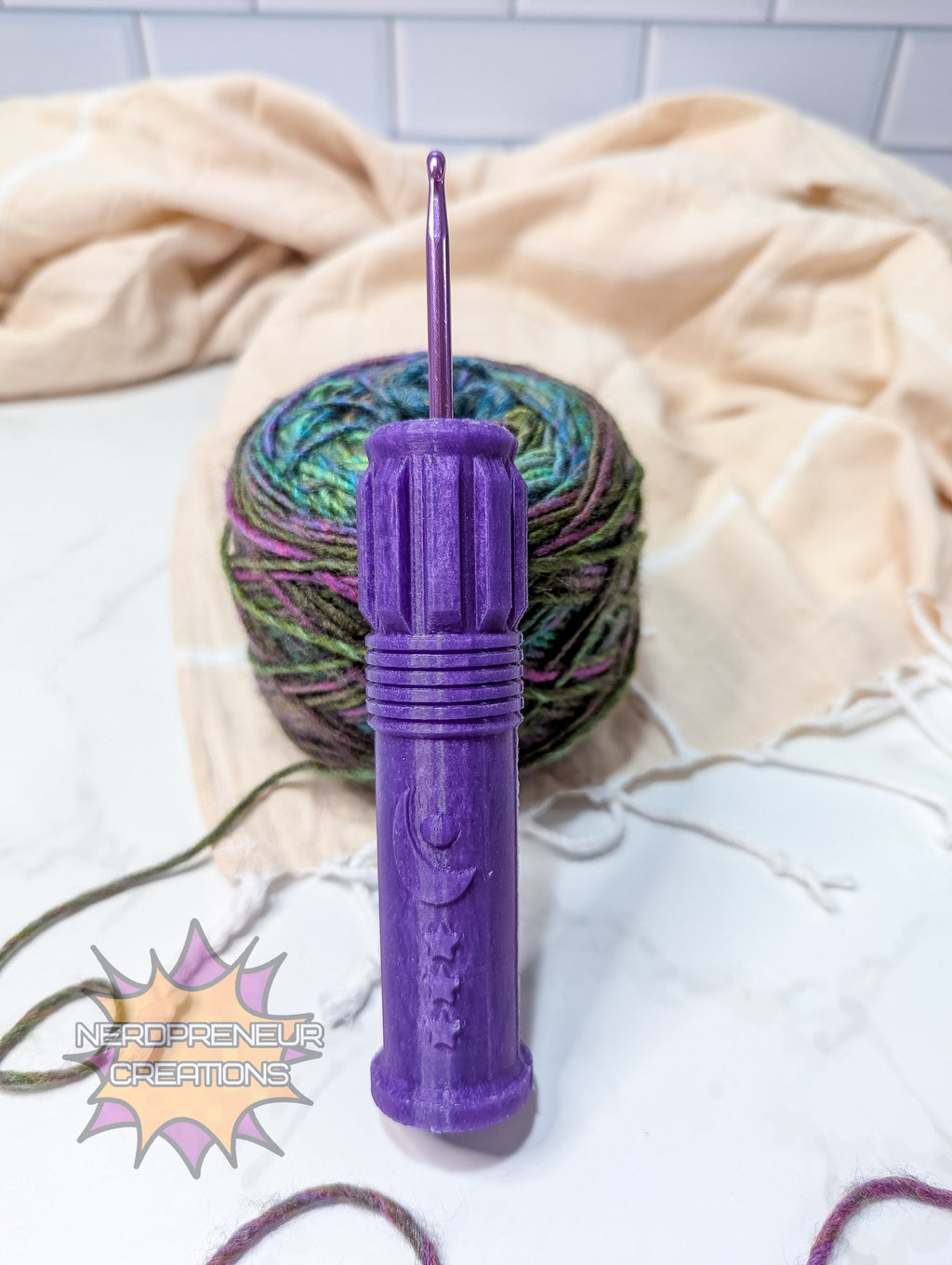 Purple silicone crochet grip with a ball of yarn on a light-colored blanket
