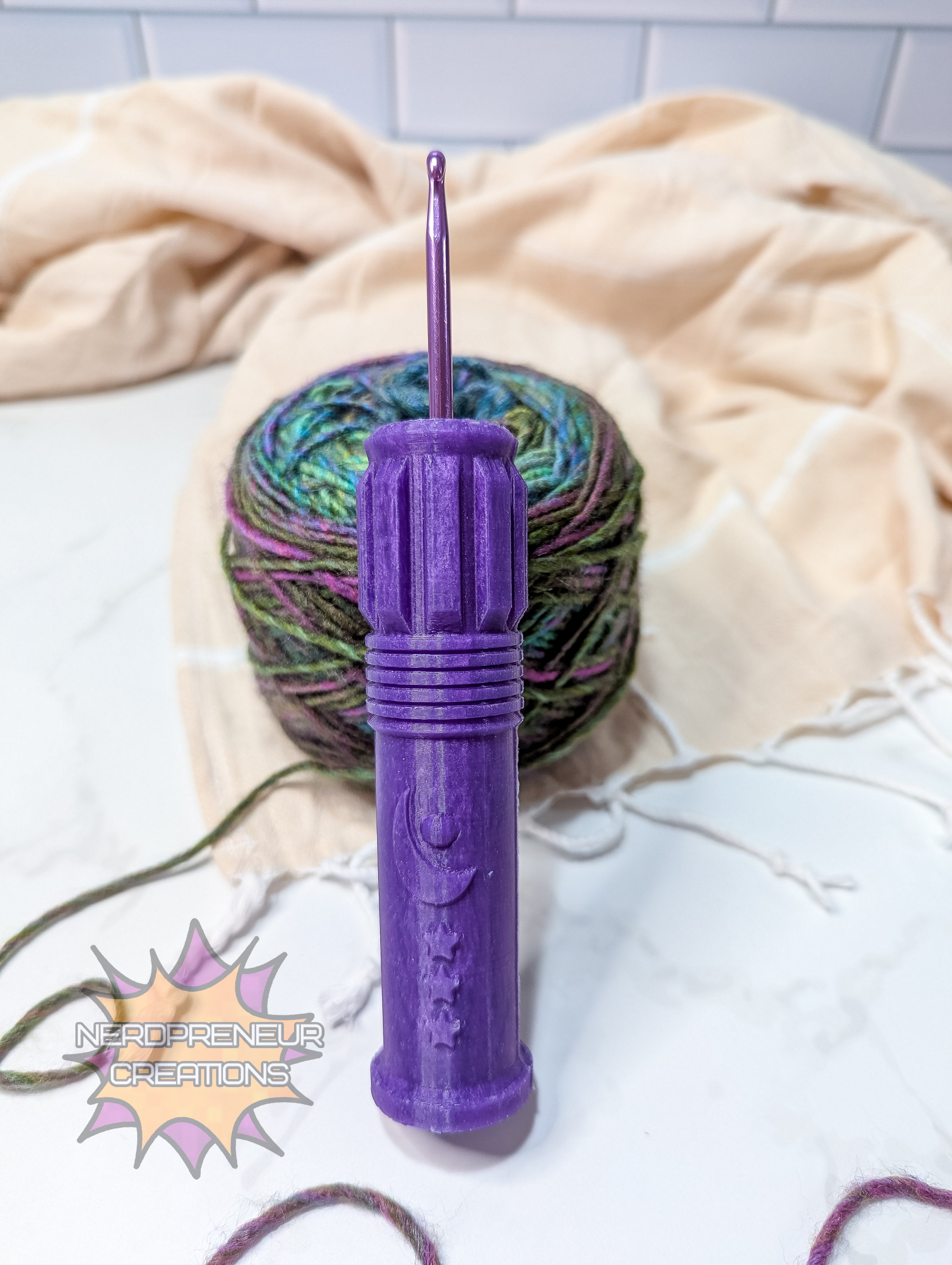 Purple silicone crochet grip with a ball of yarn on a light-colored blanket