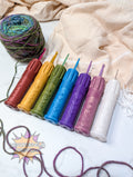 Set of colorful silicone crochet grips on a textured fabric background with yarn.