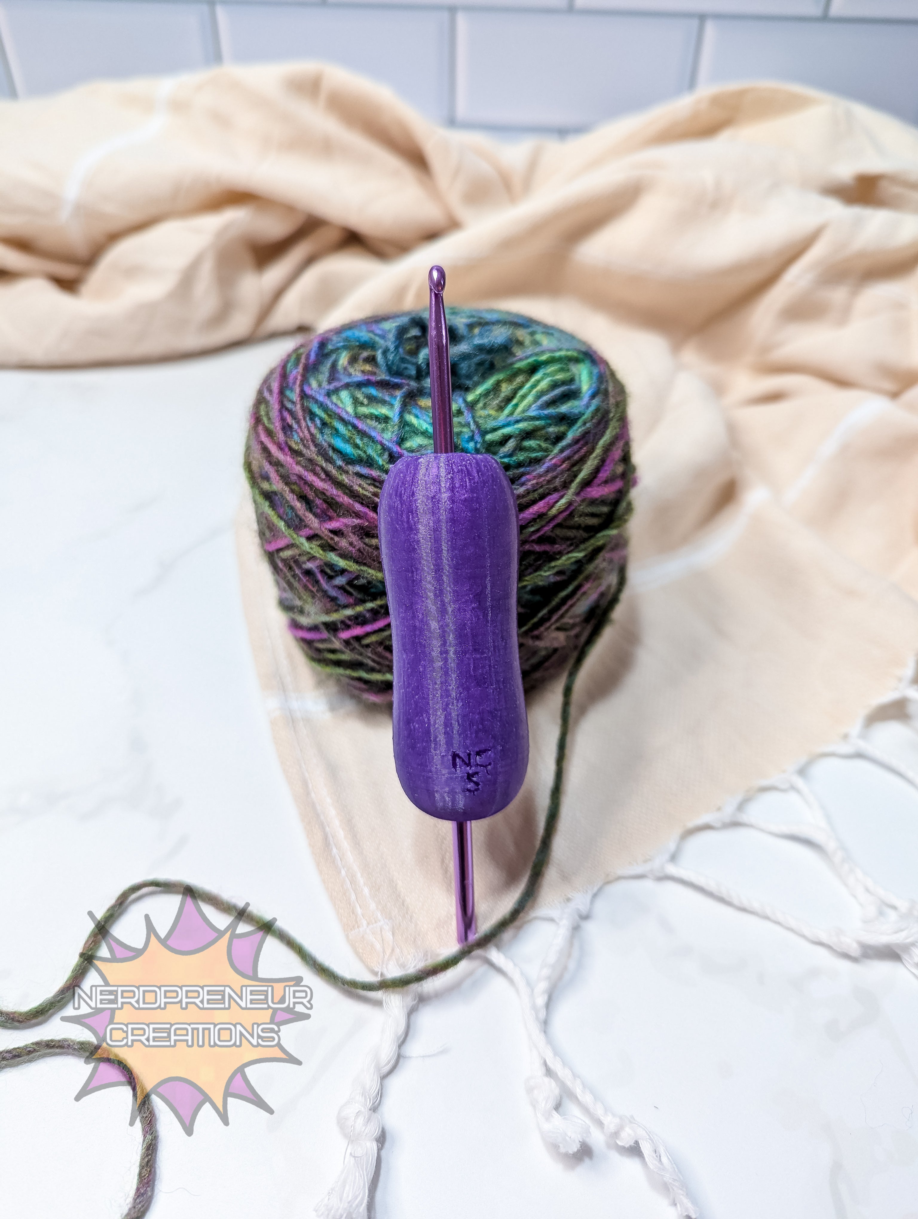 Purple silicone crochet grip with a ball of multicolored yarn on a light surface.