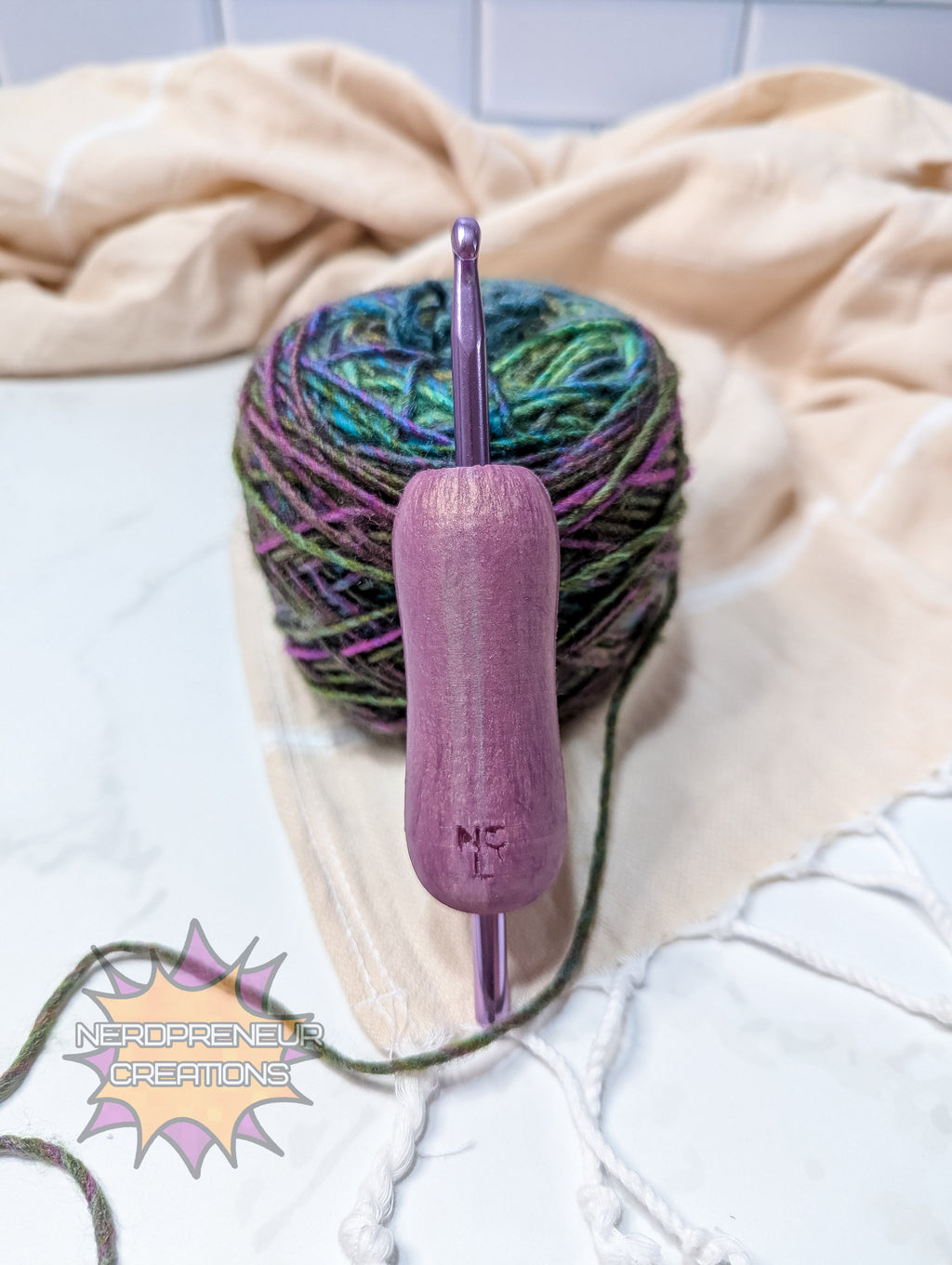 Ball of yarn with a pink silicone crochet grip on a light background