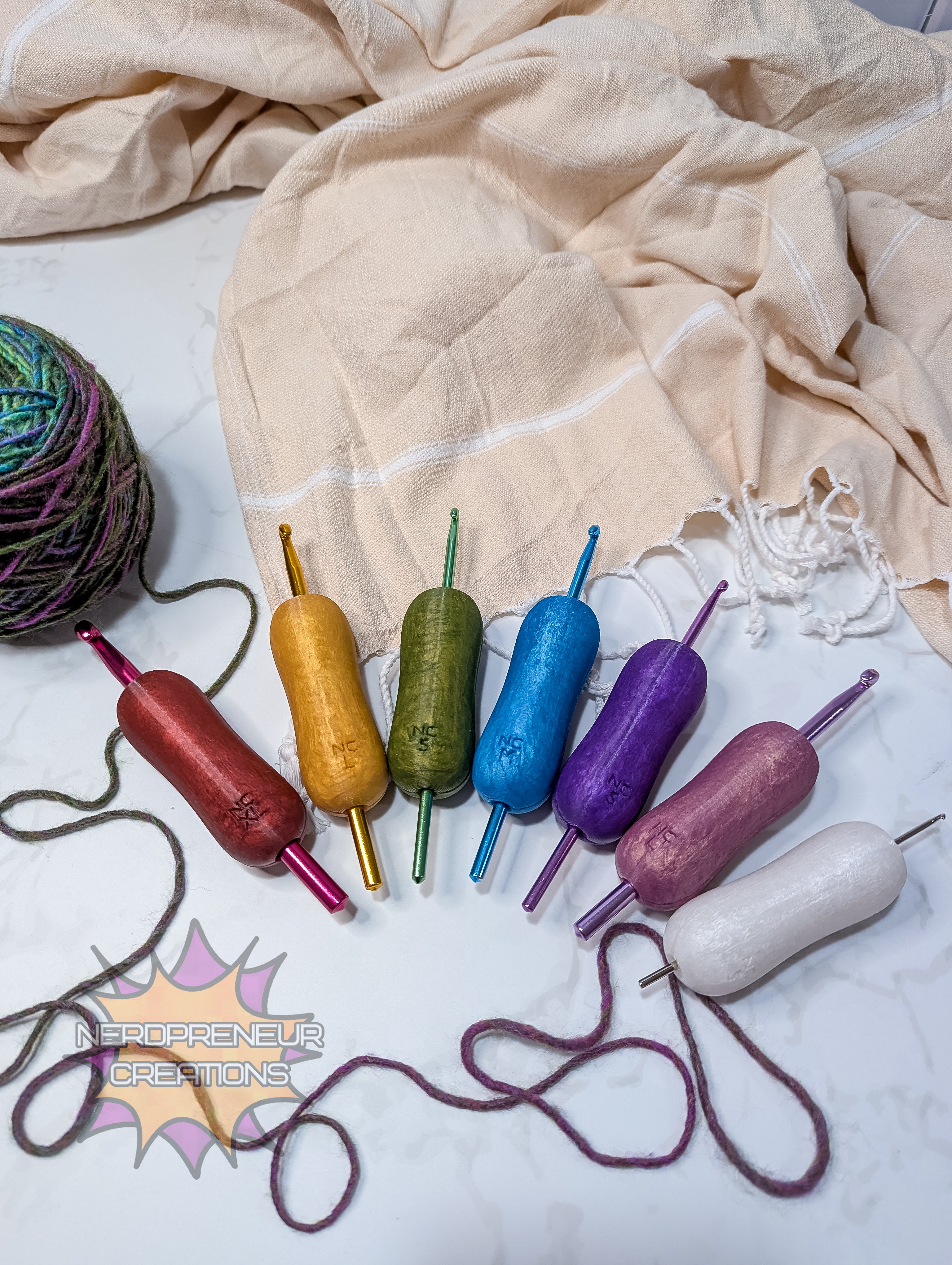 Colorful silicone crochet grip arranged on a textured fabric surface with a yarn ball and lacework.