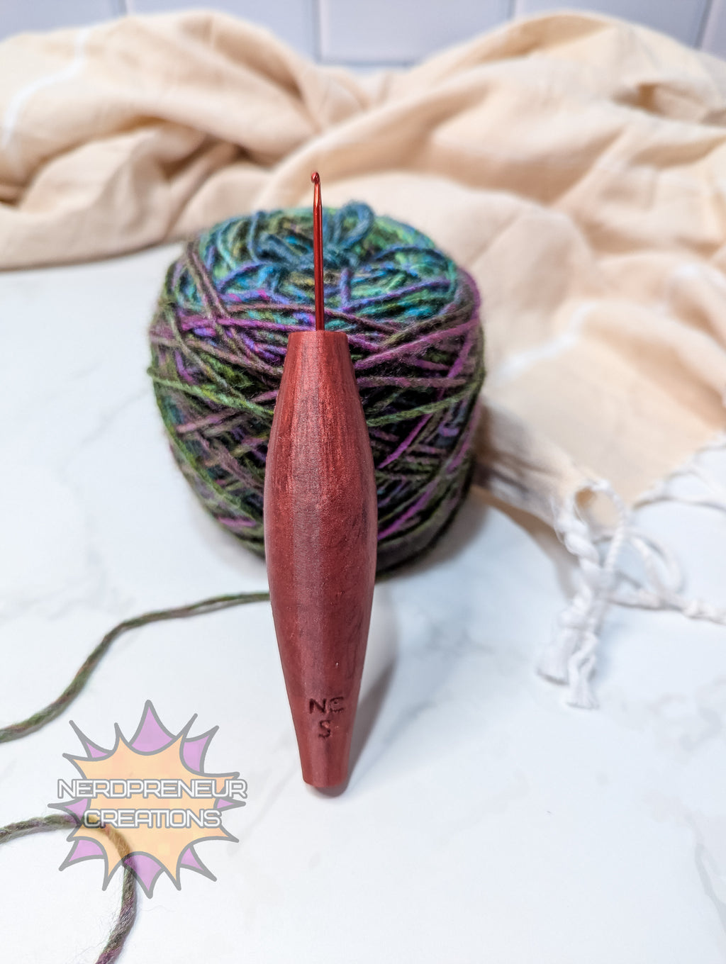 Red silicone crochet grip with multicolored yarn on a light fabric background