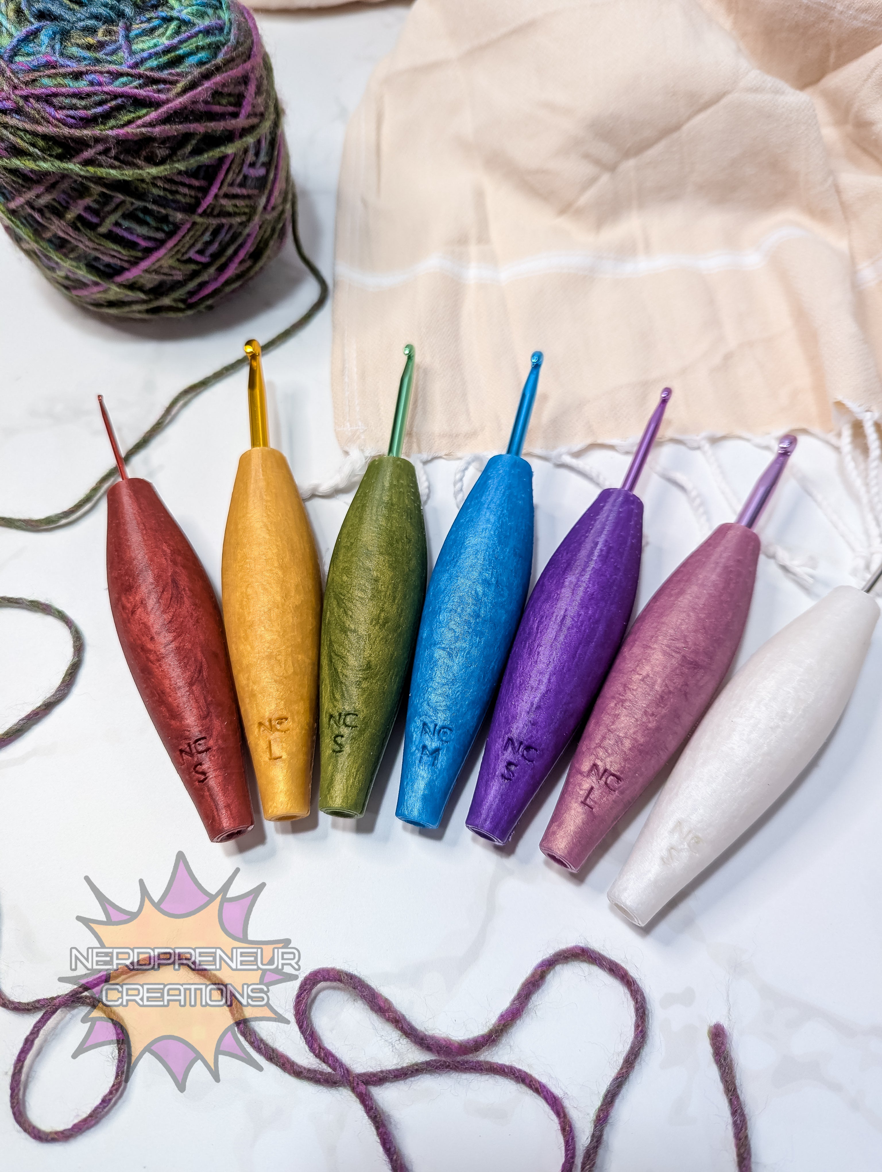 Set of colorful silicone crochet grips with a ball of yarn and fabric on a light background