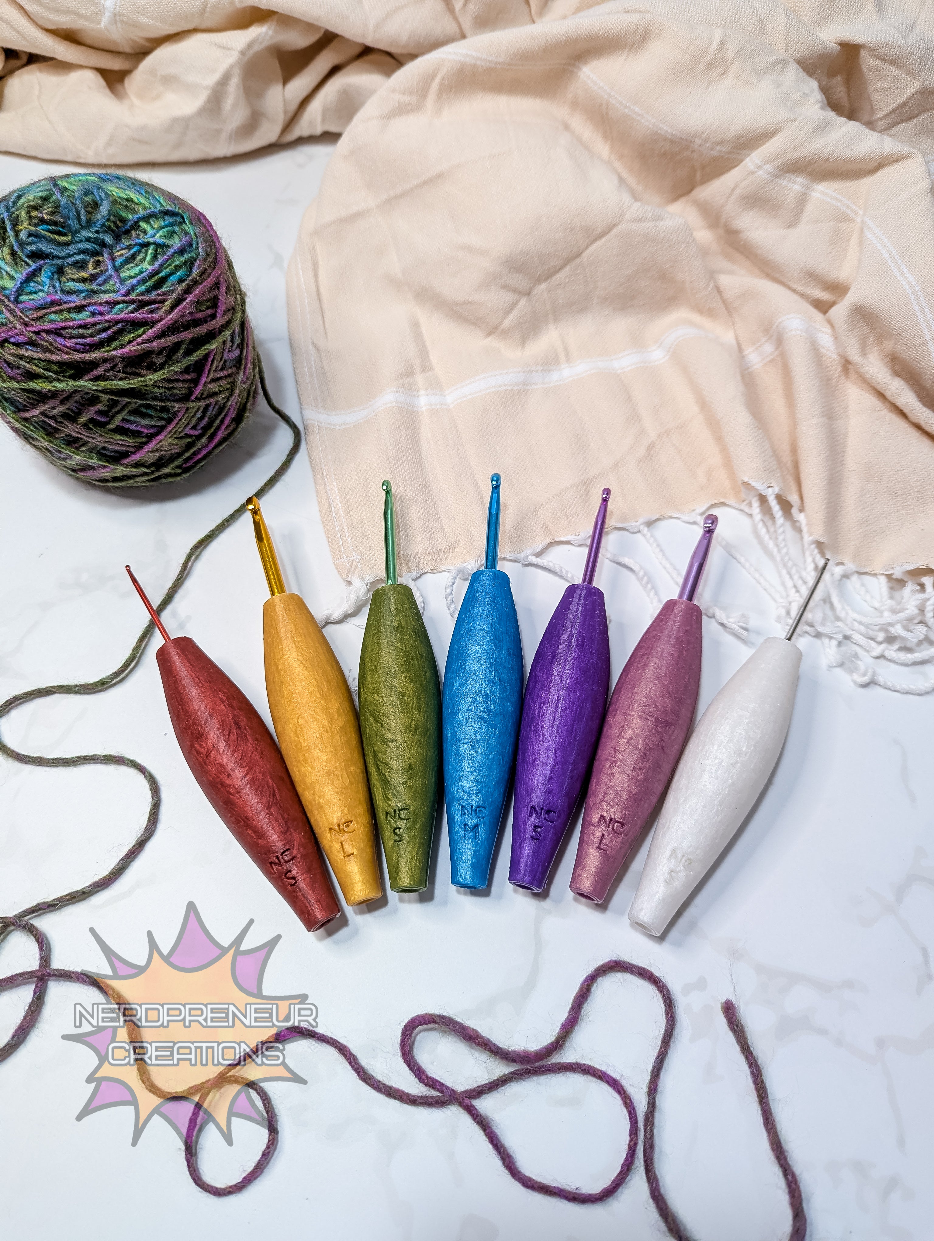 Colorful silicone crochet grips on a marble surface with a ball of yarn and fabric.