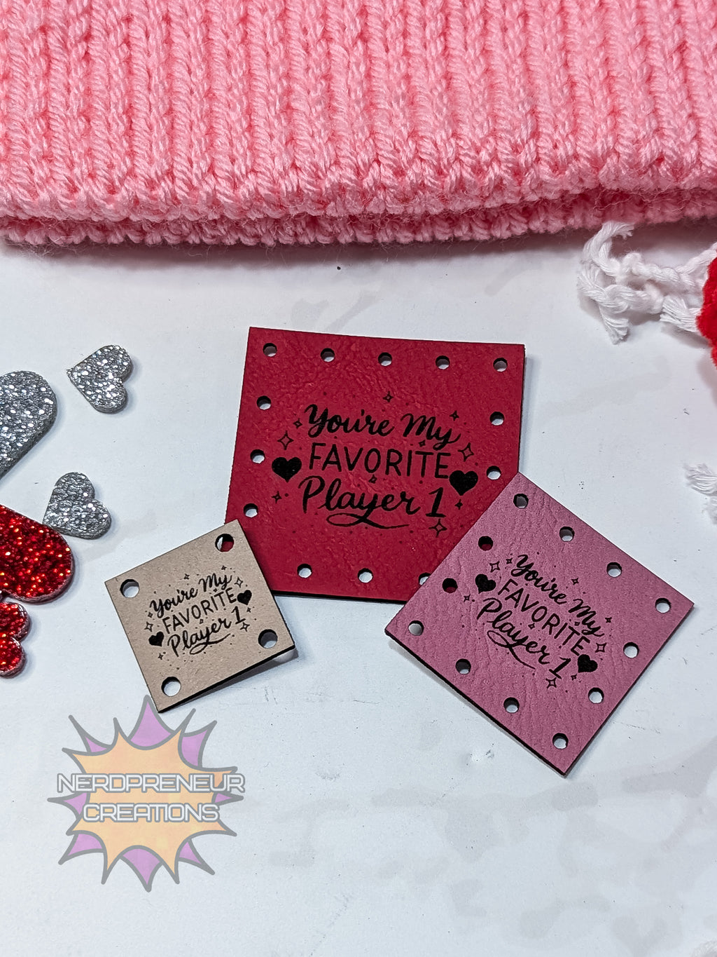 Red and pink faux leather patches with 'You're my favorite player' text on a white surface with pink fabric in the background.